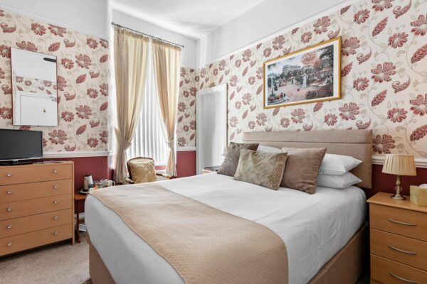 Bedroom with pattern on the walls and white linen