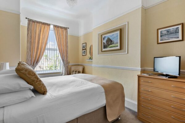 Bedroom with yellow walls and white linen